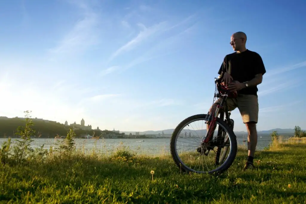 homme sur un vélo au bord d'un fleuve